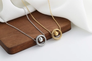 Detail of silver and gold spinning bead necklaces on elegant display stand