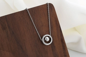 Detail shot of celestial silver necklace pendant with sparkling stones on dark wood