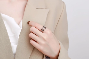 Close-up of a silver double-layer open ring with three sliding beads on woman's finger