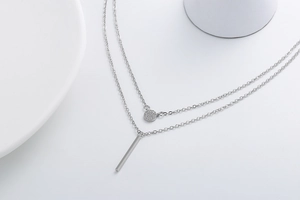 Detail of silver double layer necklace with micro-pave round and bar pendants