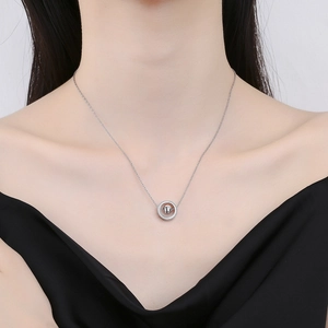 Minimalist silver interlocking circle necklace with bead pendant on model in black top
