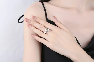 Detailed view of adjustable rotating daisy flower ring with pearl on hand
