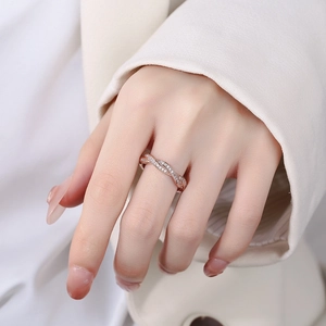 Bague entrelacée en or rose avec pavé de diamants sur la main d'un mannequin