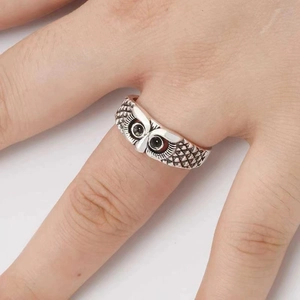 Close-up of vintage owl ring with black gemstone eyes and detailed feather texture