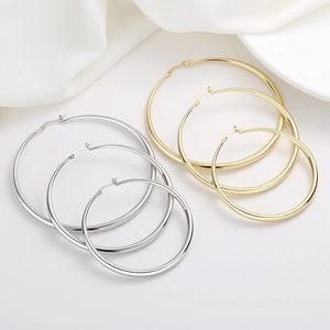 Minimalist geometric hollow gold and silver hoop earrings set in three sizes on white silk