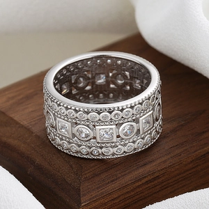 Exquisite wide silver band ring with micro-pave cubic zirconia on a rustic wood base