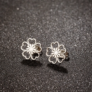 Vue macro de boucles d'oreilles fleurs en acier inoxydable avec découpes en forme de cœur
