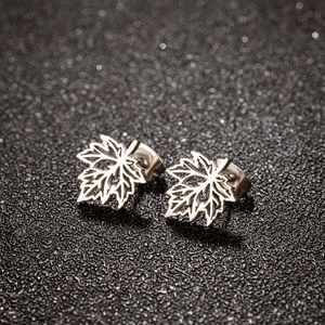 Vue macro de boucles d'oreilles clous feuille d'érable argentées avec texture évidée
