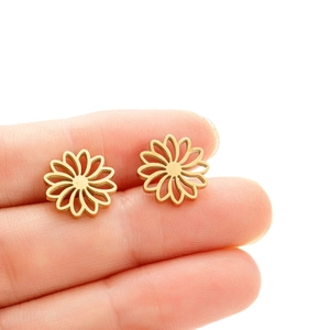Minimalist stainless steel hollow flower stud earrings in gold finish held by hand