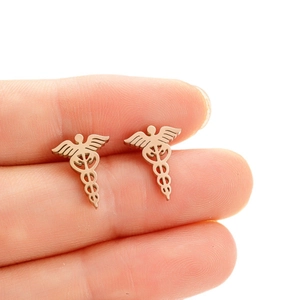 Macro detail of golden stainless steel Caduceus medical symbol stud earrings held by hand