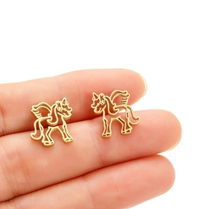 Goldene hohle Pegasus-Ohrstecker aus Edelstahl am Finger für die Größenreferenz gezeigt