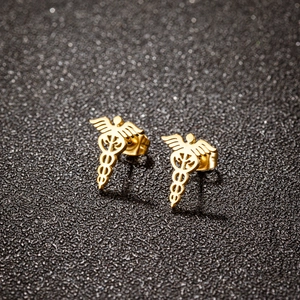Golden stainless steel Caduceus medical symbol stud earrings on textured background