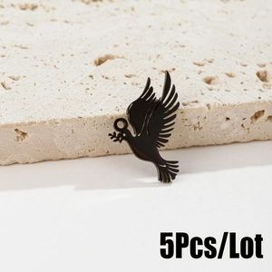 Detailed view of five black stainless steel bird pendants on a natural stone surface