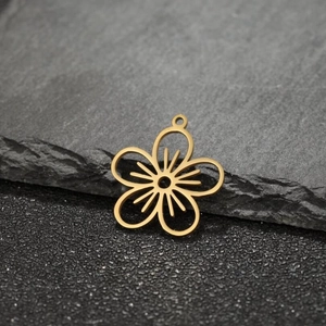 Macro detail of golden geometric flower charm on textured stone background for DIY jewelry