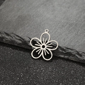 Macro shot of 18K gold floral pendant on grey stone, hollow five-petal jewelry design