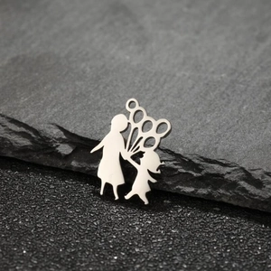Polished stainless steel mother and daughter silhouette pendant on textured slate