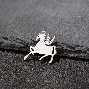 Polished silver stainless steel winged horse pendant on natural textured stone