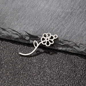 Détail macro d'un pendentif fleur en acier inoxydable argenté pour la création de bijoux