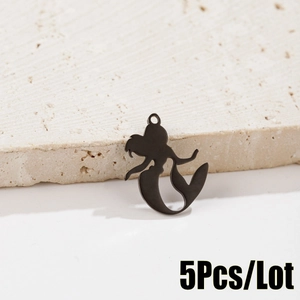 Detail showing 5pcs matte black mermaid silhouette charms on a textured stone surface