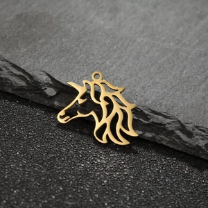 Macro view of a hollow unicorn head pendant in polished 18k gold-plated stainless steel