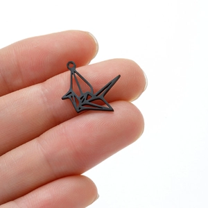 Vue macro d'un pendentif grue en origami noir mat avec détails découpés en métal évidé
