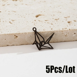 Vue détaillée de 5 pendentifs grues en origami noir ajouré sur un support en pierre