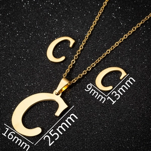 Detail of gold letter C pendant and earrings set with dimensions on black background
