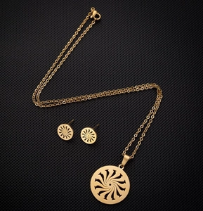 Vue détaillée d'une parure de bijoux dorés en acier avec motif de tourbillon solaire