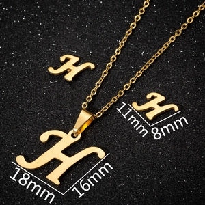 Macro shot showing size dimensions for gold cursive letter H necklace and earrings set