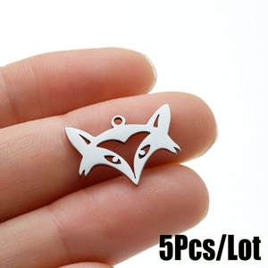 Polished stainless steel fox head pendant charm with hollow cutout design held in hand