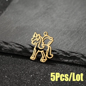 Macro view of gold stainless steel unicorn charms for DIY jewelry on dark stone