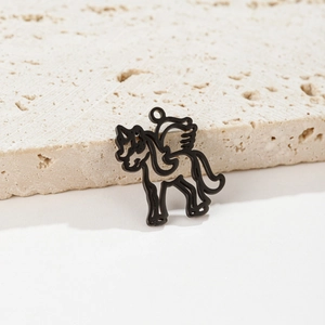 Detailed view of a black hollow unicorn pendant for DIY jewelry making on stone background