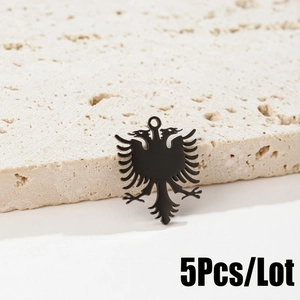 Detailed view of five black stainless steel double-headed eagle pendants on stone base