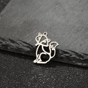 Detailed macro shot of silver hollow origami squirrel pendant on dark textured rock surface