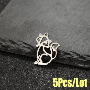 Macro shot of 5pcs origami fox stainless steel pendants on a textured stone surface