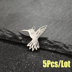 Détail macro de pendentifs colibri en acier poli pour la création de bijoux DIY