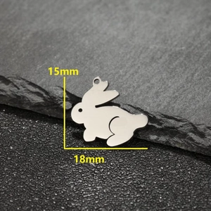 Set of 5 cute rabbit shaped stainless steel pendants on a stone surface with size measurements
