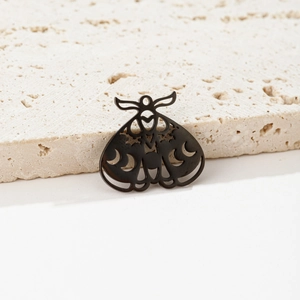 Close-up of black moth pendant with hollow crescent moon and heart cutouts on stone