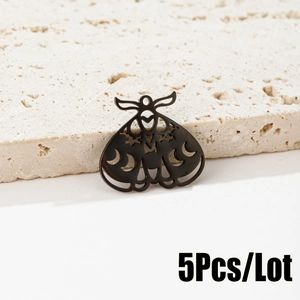 Macro detail of gothic moth pendant with moon cutouts on 18K gold plated steel