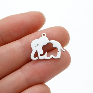 Vue détaillée du pendentif éléphant argenté tenu à la main pour référence de taille