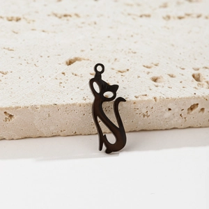 Minimalist black stainless steel cat-shaped pendant shown on textured travertine stone