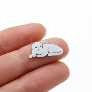 Cute stainless steel lying cat pendant with mirror finish held between fingertips