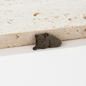 Macro shot of matte black metal leopard charm with fine brushed texture on stone