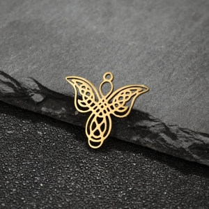 Detailed macro view of golden stainless steel hollow angel pendant with Celtic knot design