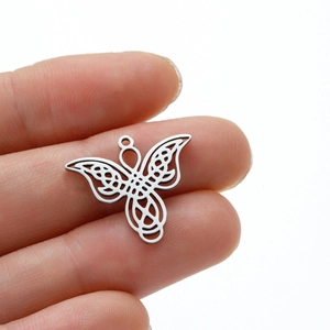 Detailed view of silver butterfly pendant with Celtic knot wings held by hand