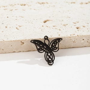 Detailed macro of black gothic angel wing pendant with Celtic knot on stone surface