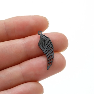 Detailed macro of a black cutout angel wing pendant made of stainless steel