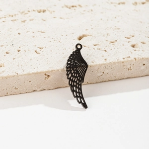 Vue détaillée d'un pendentif aile d'ange noir évidé pour bijoux DIY sur socle en pierre