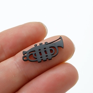 Vue rapprochée d'un petit pendentif trompette noir mat montrant des détails fins