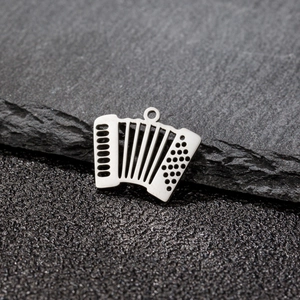Macro shot of accordion shaped stainless steel pendant with fine etched details on slate